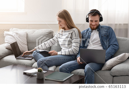 Millennial couple spending time with gadgets online 65163113