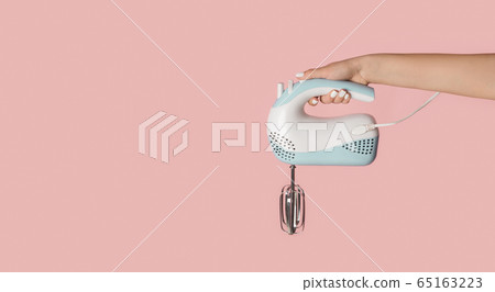 Millennial girl holding electric mixer on pink background, closeup. Empty space. Panorama 65163223