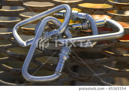 Steel carabiners on expanded metal mesh. Steel carabiners on expanded metal mesh. 65165554