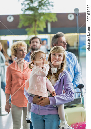 Family on holiday trip queueing for check in at airport Family on holiday trip queueing for check in at airport 65165983