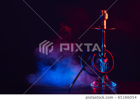 hookah with a glass flask and a metal bowl shisha with colored smoke on the table hookah with a glass flask and a metal bowl shisha with colored smoke on the table 65166054