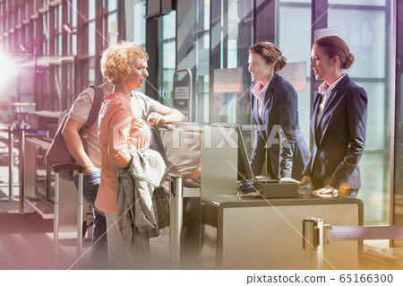 Portrait of mature couple asking airport staff 65166300