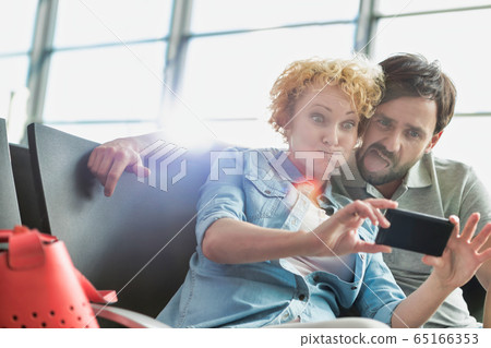 Portrait of mature couple taking selfie while Portrait of mature couple taking selfie while 65166353