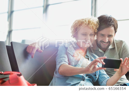 Portrait of mature couple taking selfie while Portrait of mature couple taking selfie while 65166354