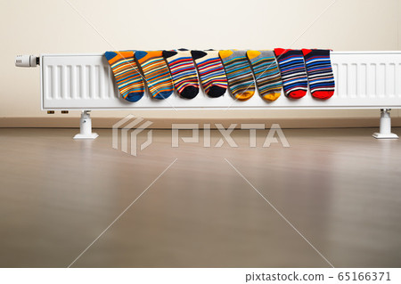 colorful socks are being drying on the radiator colorful socks are being drying on the radiator 65166371