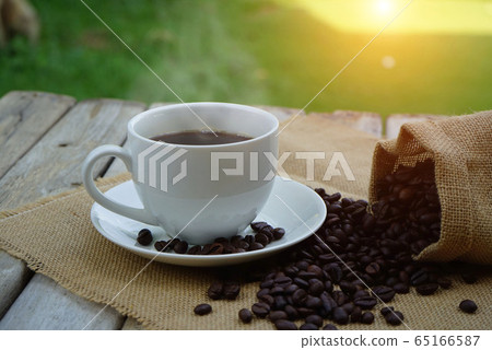 Hot Coffee cup and coffee beans roating on the Hot Coffee cup and coffee beans roating on the 65166587