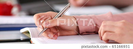 Close up female hands make an entry in diary 65166931