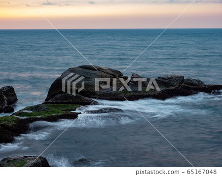 beautiful silky smooth water waves and rocks on the sea shore beautiful silky smooth water waves and rocks on the sea shore 65167048
