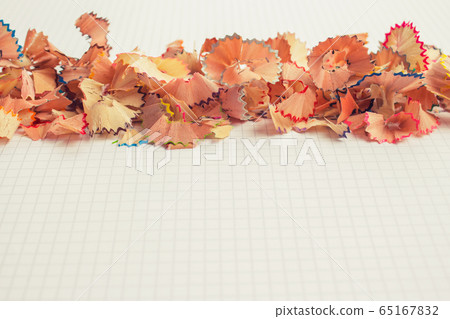 Color pencils shavings on white notebook page as creative background with copy space. Back to school concept 65167832