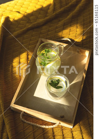 Water with lemon in a transparent bowl on a tray. 65168115