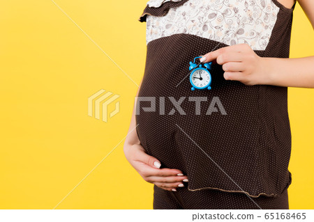 Close up of pregnant woman in brown pajamas 65168465