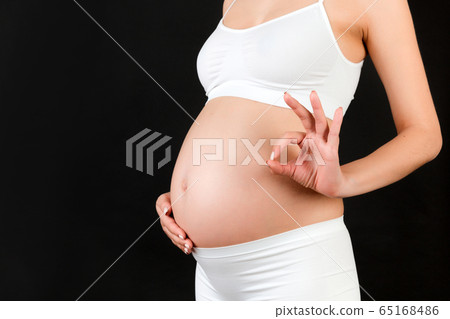 Close up of happy pregnant woman in white 65168486