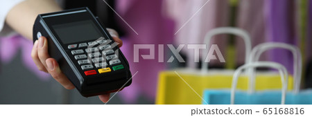 Hand holds out terminal for credit card payment Hand holds out terminal for credit card payment 65168816