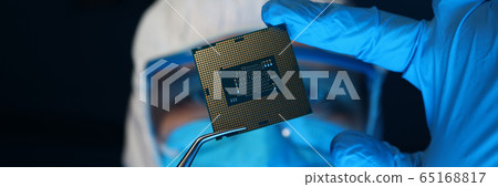 Man in uniform holds microprocessor with forceps 65168817
