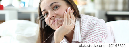 At home on bed lies cheerful girl in pajamas 65168821