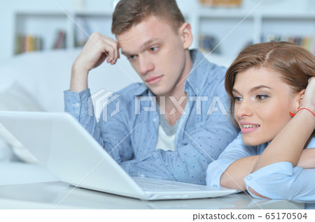 Portrait of young couple with laptop at home 65170504