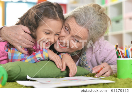Portrait of grandmother and granddaughter drawing together Portrait of grandmother and granddaughter drawing together 65170525