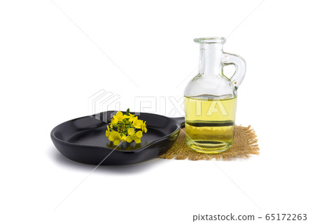 Yellow mustard flowers with decanter of oil 65172263
