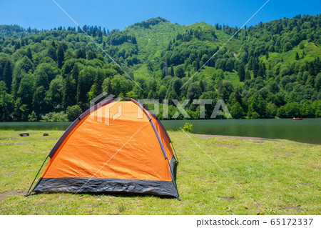 Camping tent at scenic campsite on a lake 65172337