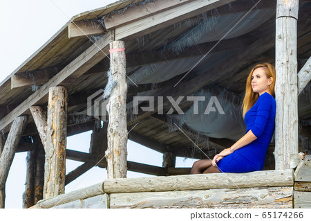 A slender thoughtful girl in a blue dress was 65174266