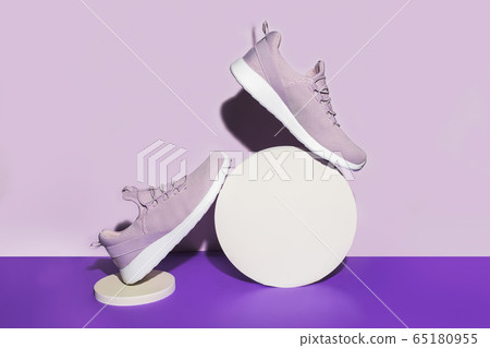 New purple sneakers on colorful background with round fhapes. Creative shot of running shoes New purple sneakers on colorful background with round fhapes. Creative shot of running shoes 65180955