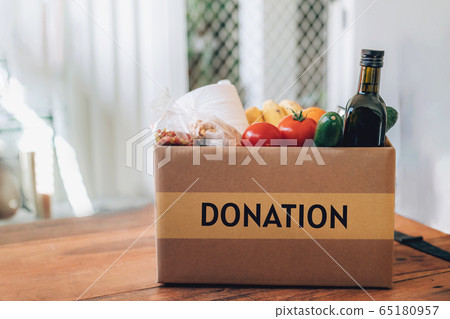 Box with food, toilet paper and hand sanitizer on the wooden table. Flat lay. Box with food, toilet paper and hand sanitizer on the wooden table. Flat lay. 65180957
