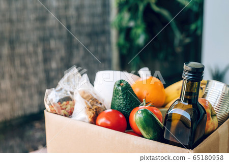 Box with food, toilet paper and hand sanitizer on the wooden table. Flat lay. Box with food, toilet paper and hand sanitizer on the wooden table. Flat lay. 65180958