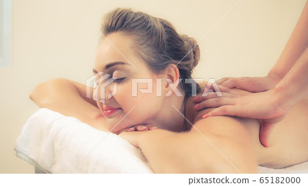 Woman gets back massage spa by massage therapist. 65182000