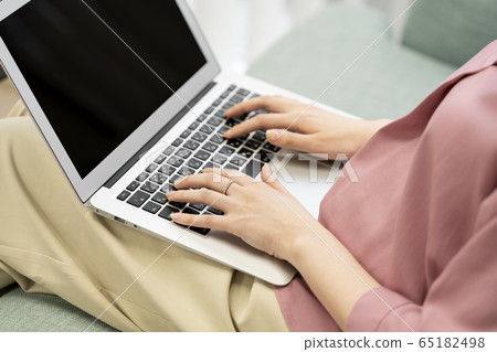 Woman's hand operating a laptop 65182498