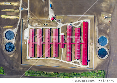 Aerial view of a large pig farm on an agricultural field in spring. Aerial view of a large pig farm on an agricultural field in spring. 65183279