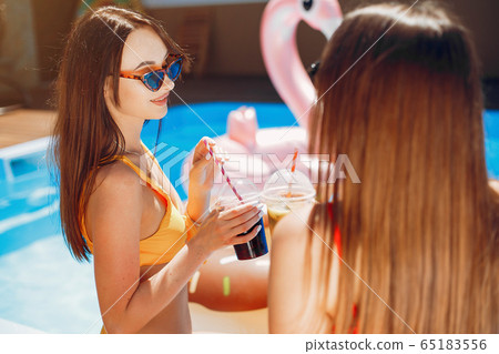 Girls on summer party in the swimming pool 65183556
