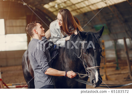 Cute loving couple with horse on ranch 65183572