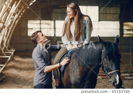 Cute loving couple with horse on ranch 65183580