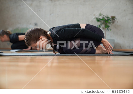 Fit woman practicing child pose in hall. Fit woman practicing child pose in hall. 65185485