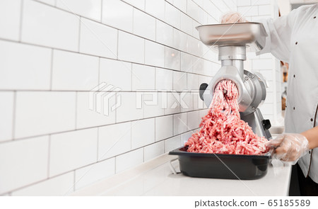 Incognito female butcher doing minced meat. Incognito female butcher doing minced meat. 65185589