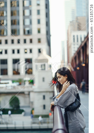 young lady crossing the bridge in the city 65185716