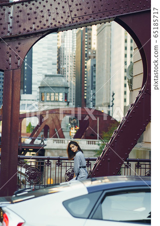 young lady crossing the bridge in the city 65185717