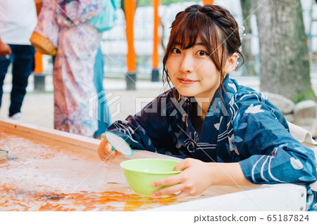 A girl who scoops goldfish scooping 65187824