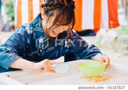 A girl who scoops goldfish scooping 65187827