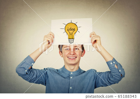 Smiling teenager boy holding a paper sheet with a 65188343
