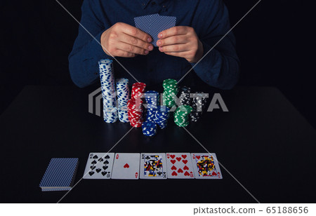 Close up of guy poker player hands holding cards Close up of guy poker player hands holding cards 65188656