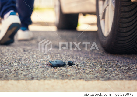 Car key fall on the asphalt road. Driver lost his 65189073