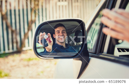 Casual guy driver showing car keys in the side Casual guy driver showing car keys in the side 65189076