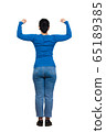 Rear view woman full body showing and flexing arm 65189385