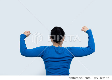 Portrait of a happy woman showing her biceps on Portrait of a happy woman showing her biceps on 65189386