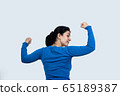 Portrait of a happy woman showing her biceps on 65189387