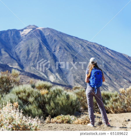 Young tourist woman near the Teide volcano Young tourist woman near the Teide volcano 65189622