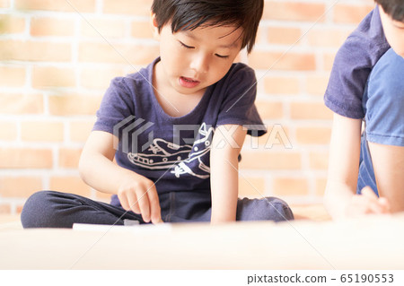 Boy drawing in the room 65190553