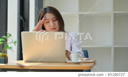 A young woman uses a laptop for work,She works 65190727