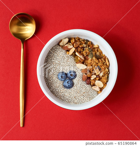 Detox and healthy superfoods breakfast bowl concept. Vegan coconut milk chia seeds pudding, blueberries and nuts. Overhead, top view, flat lay. Detox and healthy superfoods breakfast bowl concept. Vegan coconut milk chia seeds pudding, blueberries and nuts. Overhead, top view, flat lay. 65190864